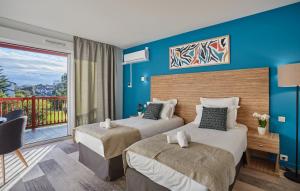 2 camas en una habitación de hotel con balcón en Hôtel Prestige Odalys Erromardie en San Juan de Luz
