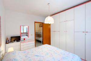 a bedroom with a bed and a dresser and a mirror at Cala Rossa Pool & Nature - Goelba in Nisporto