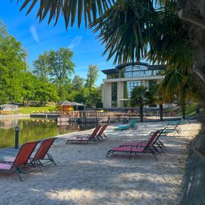 um grupo de cadeiras de jardim sentadas em frente a um edifício em Le Forges Hotel em Forges-les-Eaux