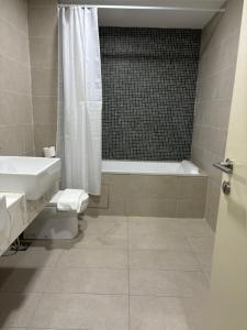 een badkamer met een bad, een wastafel en een douche bij The Ooak Suites, Kiara 163 by Bamboo Hospitality in Kuala Lumpur