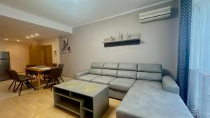 a living room with a couch and a table at Bratanov Flower Street Apartment in Sunny Beach