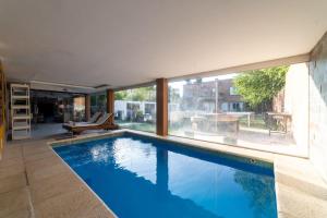una piscina en una casa con una ventana grande en APART HOTEL SPA BUENOS AIRES EZEIZA DEP 2 A 20 minutos de aeropuerto ministro pistarini ezeiza en Ezeiza