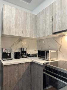 a kitchen with stainless steel appliances and wooden cabinets at The lighthouse in Chalkida