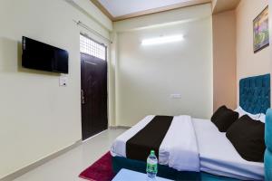 Hotel Maujis Inn في Prayagraj: غرفه فندقيه سرير وتلفزيون