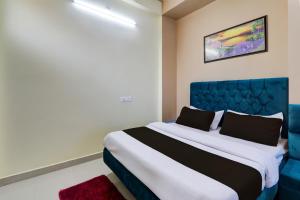 Hotel Maujis Inn في Prayagraj: غرفة نوم بسرير ازرق واريكة زرقاء