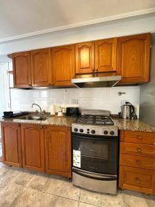 Una cocina con gabinetes de madera y un horno de estufa. en Paramont Tucuman 2, en San Miguel de Tucumán 16 fotos más