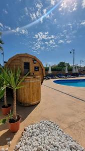 - un grand bâtiment en bois à côté d'une piscine dans l'établissement Mar Menor Golf Resort - Casa Destino, à Torre-Pacheco