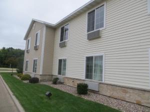 a white house with a grass yard at Cobblestone Inn & Suites - Brillion in Brillion