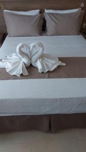 a bed with two white towels on it at Wind e Blue in Jericoacoara