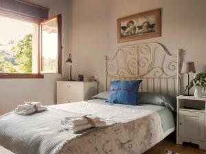 Un dormitorio con una cama blanca con toallas. en Casa La Escuelina en Villanueva, en Villanueva