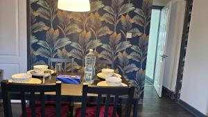 a dining room table with a blue and gold wallpaper at Charming 2-Bedroom Home with Modern Amenities in Oldham