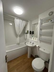 a white bathroom with a toilet and a sink at The Imperial Hotel Exmouth in Exmouth