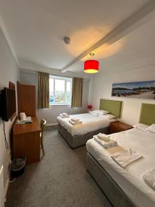 a hotel room with two beds and a television at The Imperial Hotel Exmouth in Exmouth