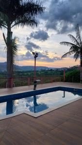 a swimming pool with a sunset in the background at Pousada Vale dos Sonhos - Suite Master com Hidromassagem in Capitólio +28 photos
