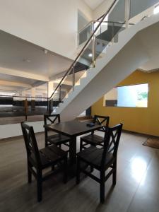 ein Esszimmer mit einem Tisch, Stühlen und einer Treppe in der Unterkunft Hotel Villa in San Juan del Paraná