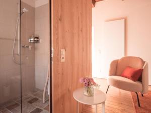 a bathroom with a shower and a chair and a table at B&B CCAA Ascona in Ascona