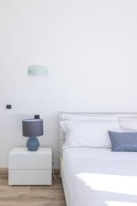 una camera bianca con un letto e una lampada su un comodino di Maison Blu - in Trastevere a Roma