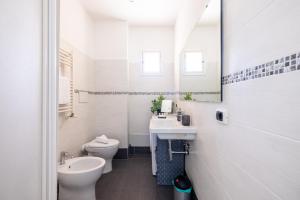 bagno con servizi igienici, lavandino e specchio di Maison Blu - in Trastevere a Roma