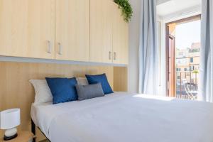 una camera da letto con un letto con cuscini blu e una finestra di Maison Blu - in Trastevere a Roma