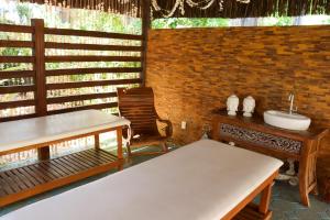 een kamer met een wastafel, een tafel en een stoel bij Hotel Coral Beach in Tamandaré