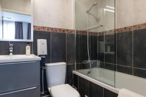 a bathroom with a toilet and a shower and a sink at The Originals City, Hôtel Notre Dame, Rouen in Rouen