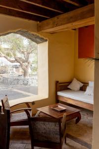 サン・バルトロメにあるFinca Tomarenのベッド、テーブル、窓が備わる客室です。