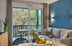 a living room with a couch and a balcony at Résidence Odalys Domaine Iratzia in Saint-Jean-de-Luz