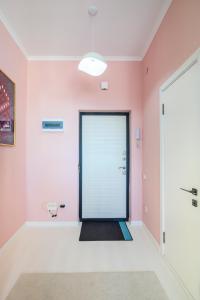pasillo con puerta en una habitación con paredes rosas en Апартаменты с видом на горы на Аль-Фараби en Almaty