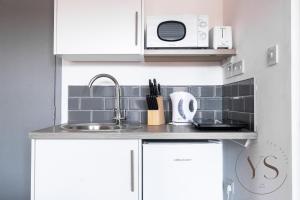 a kitchen with a sink and a microwave at Gorgeous Longton Studio 1b in Stoke on Trent