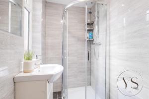 a white bathroom with a shower and a sink at Gorgeous Longton Studio 1b in Stoke on Trent