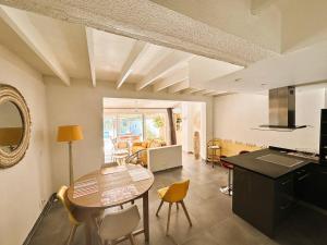 eine Küche und ein Esszimmer mit einem Tisch und Stühlen in der Unterkunft Mazet provencal climatisé avec piscine privée pour 4 pers Domaine privé in La Londe-les-Maures