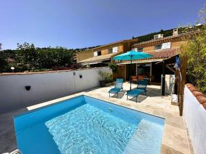 einen Pool mit 2 Stühlen und einem Sonnenschirm in der Unterkunft Mazet provencal climatisé avec piscine privée pour 4 pers Domaine privé in La Londe-les-Maures