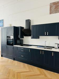 a kitchen with black cabinets and a counter top at 6 Wye Valley Chambers, Ross-on-Wye in Ross on Wye