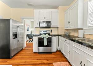 a kitchen with white cabinets and stainless steel appliances at Luxury Duplex 4 BR House In Jacksonville in Jacksonville