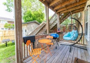 a porch with a swing and a table and chairs at Luxury Duplex 4 BR House In Jacksonville in Jacksonville