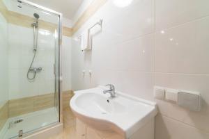 Un baño blanco con lavabo y ducha. en La Hacienda, en Vilvoorde 30 fotos más