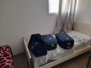 two bags of luggage sitting on a bed at Challao Dream in El Challao