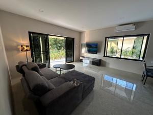a living room with a couch and a table at Vergers de Nil les roses in Ban Chawuk