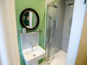a bathroom with a sink and a mirror and a shower at Pass the Keys Traditional room Tavmar Apartments in Lincoln