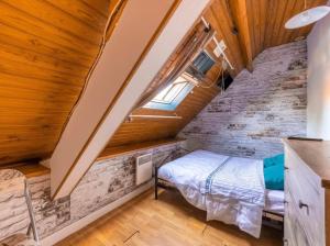 ein Schlafzimmer im Dachgeschoss mit einem Bett und einer Holzdecke in der Unterkunft La Marquisienne avec jardin in Marquise