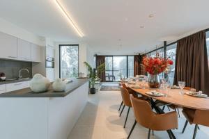 een keuken en eetkamer met een tafel en stoelen bij Apartment with two large terraces in Zedelgem