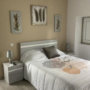 una camera da letto con un grande letto bianco e due quadri appesi al muro di Casa da Moagem a Vinhais
