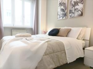 a white bedroom with a large white bed with pillows at Quick Home - Orchidea in Biella