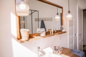 łazienka z umywalką i lustrem z oświetleniem w obiekcie Maison 15 w mieście Sauternes