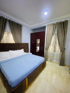 a bedroom with a large bed in front of windows at Spacious two bedroom@City center in Kadobunkuro
