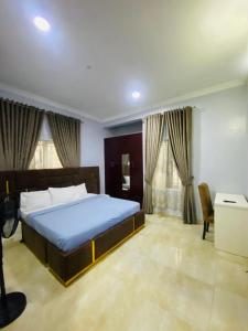 a bedroom with a bed and a desk and windows at Spacious two bedroom@City center in Kadobunkuro