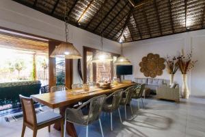 une salle à manger avec une grande table et des chaises en bois dans l'établissement Casa confortável para a família, à Barrinha