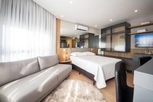 a living room with a bed and a couch at Loft 410 vista Parque Una in Pelotas