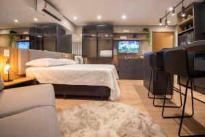 a bedroom with a bed and a living room at Loft 410 vista Parque Una in Pelotas