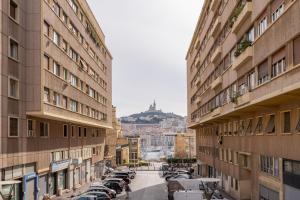 eine Stadtstraße mit zwischen zwei Gebäuden geparkt in der Unterkunft Le Lacydon - proche MUCEM in Marseille